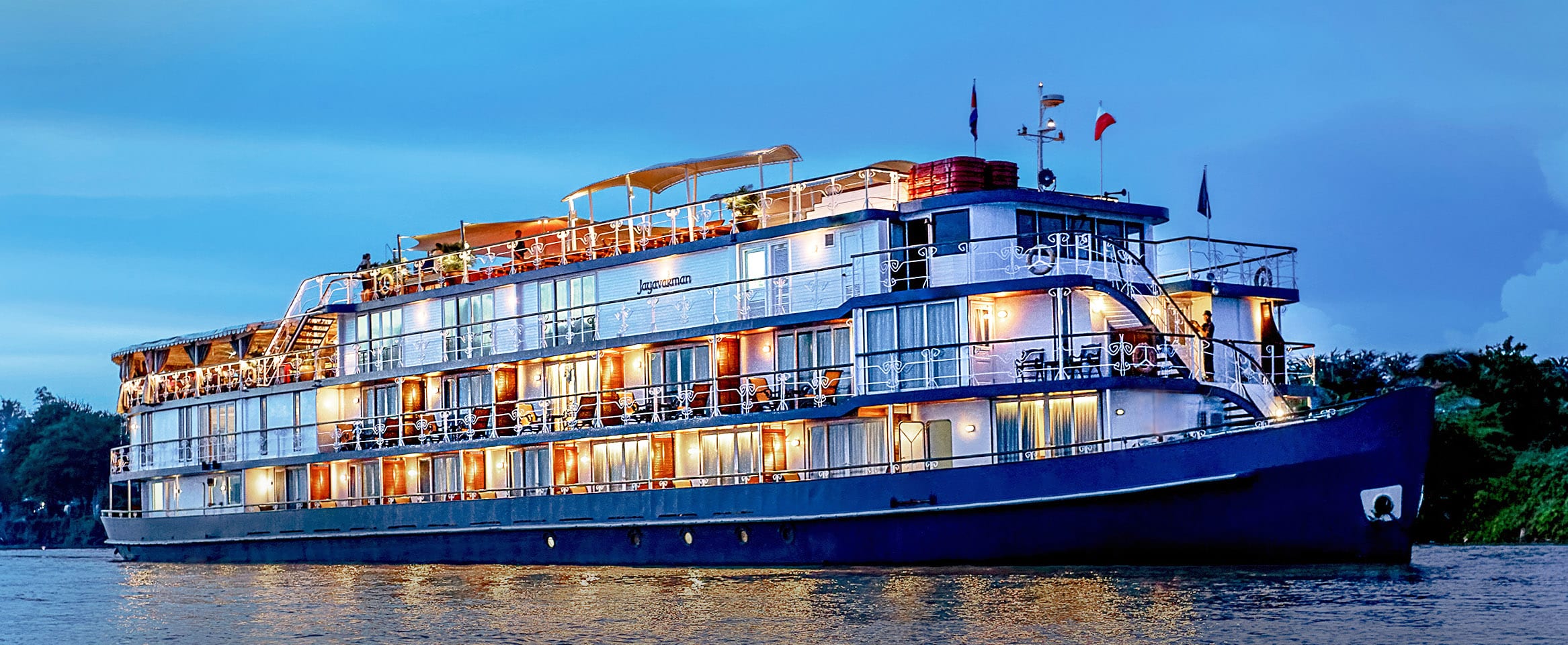 Un élégant bateau de croisière illuminé sur une rivière, parfait pour des vacances en croisière avec TMR Croisières.