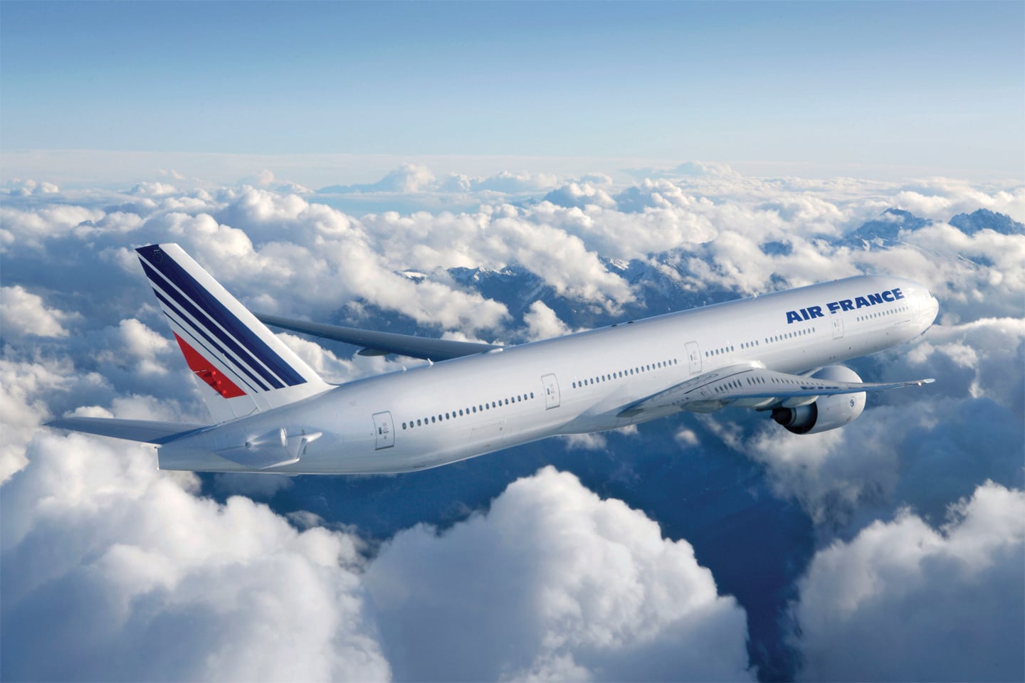 Avion Air France survolant des nuages, symbole idéal pour des voyages de luxe avec TMR Voyages.