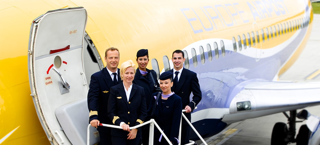 Équipe de pilote et personnel navigant prêts pour un voyage premium avec TMR Voyages, offrant des expériences authentiques et sur mesure.